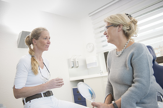 Zahnarzt-Praxis Dr. Birgit Knop Patient im Gespräch mit freundlicher Ärztin